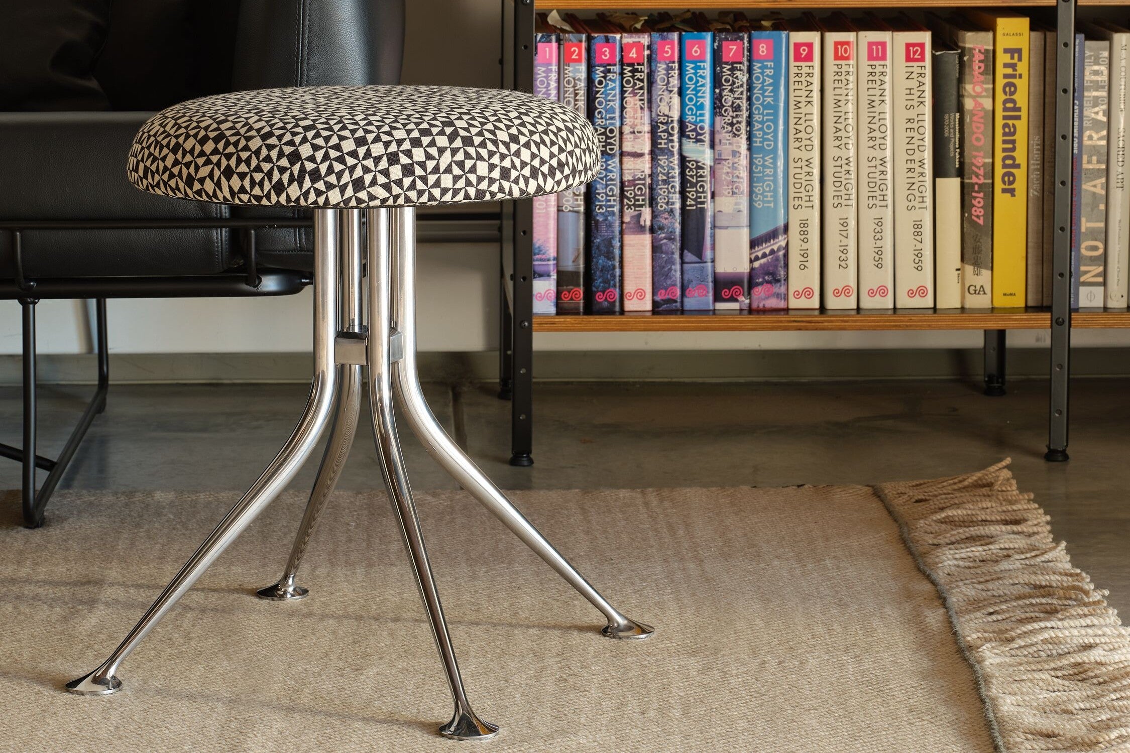 An AbakEnvironments Desk with a walnut top and polished legs, with a graphite Aeron Chair in a light home office setting and Folk Ladder Shelving.