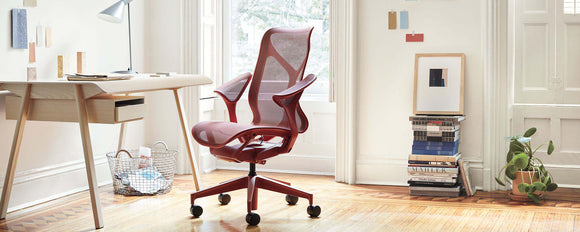 A light home office environment featuring a Canyon Red Low Back Cosm Chair against a white AbakEnvironments Desk with a white Lolly Lamp